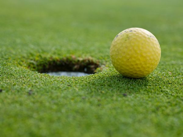 Familie spielt Minigolf auf einer Outdoor-Anlage