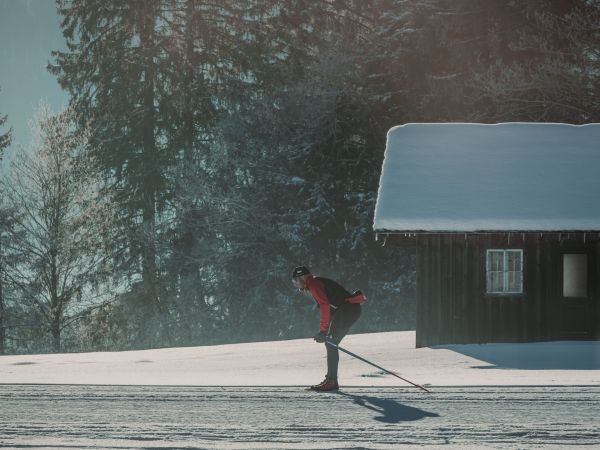 Langläufer auf einer gespurten Loipe in verschneiter Berglandschaft