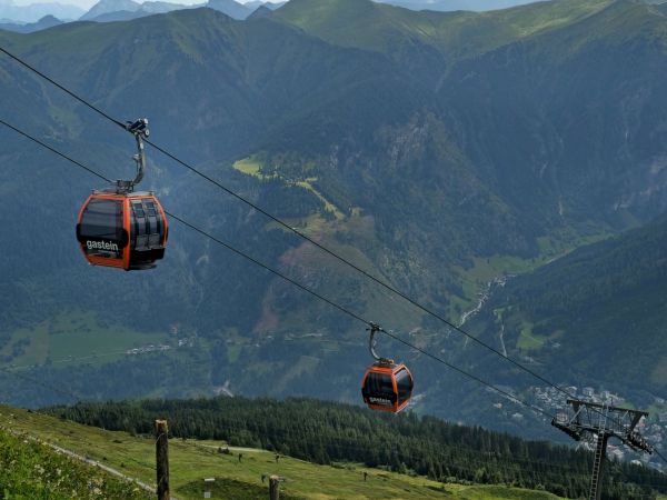 Bergbahn fährt durch alpine Landschaft mit Blick auf die Zugspitze