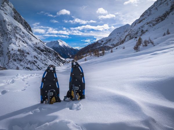 Winterwanderer auf verschneitem Weg durch einen ruhigen Bergwald